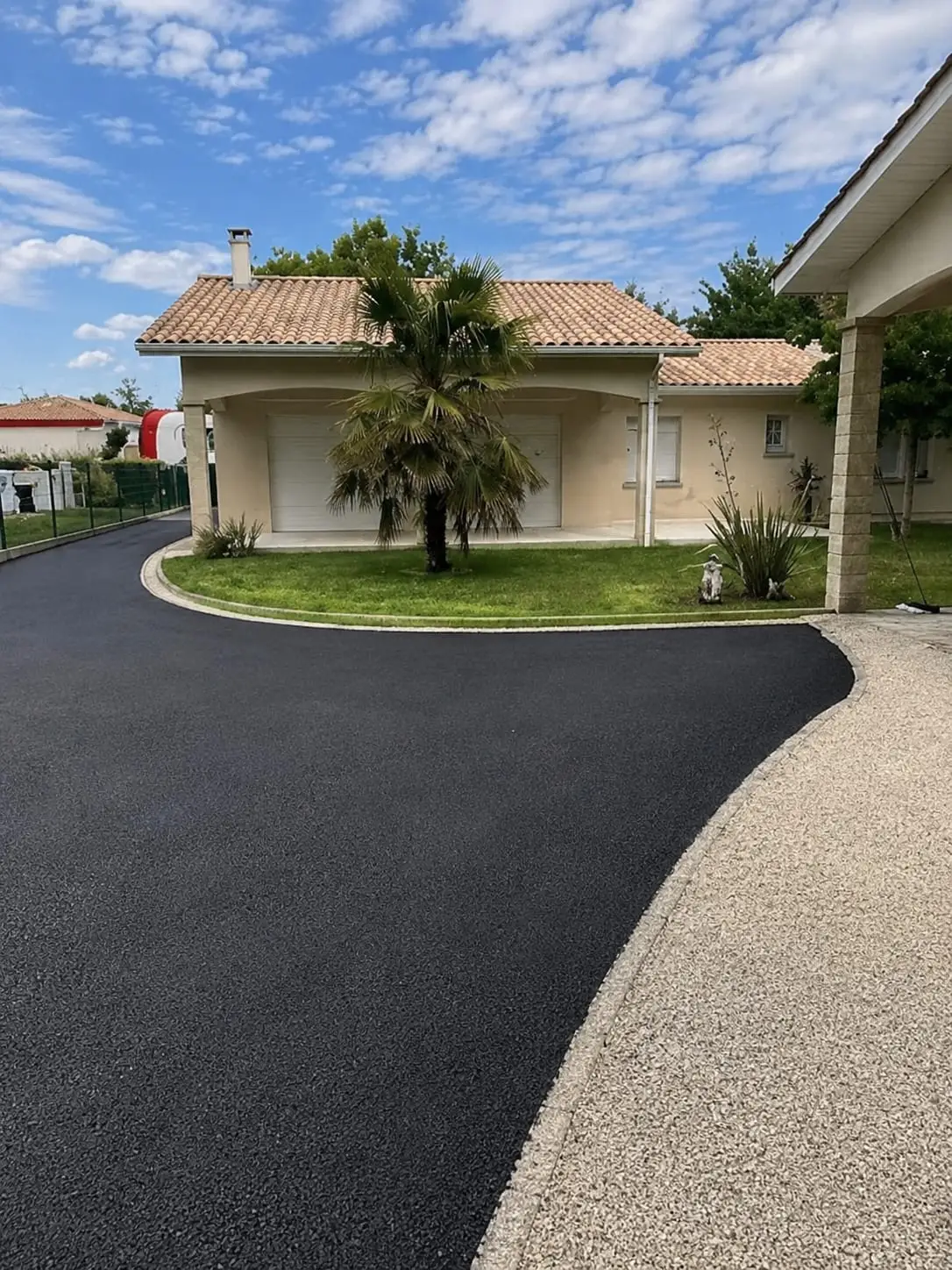 Bordure claire posée entre une maison, une bande de gravier et un terrain préparé