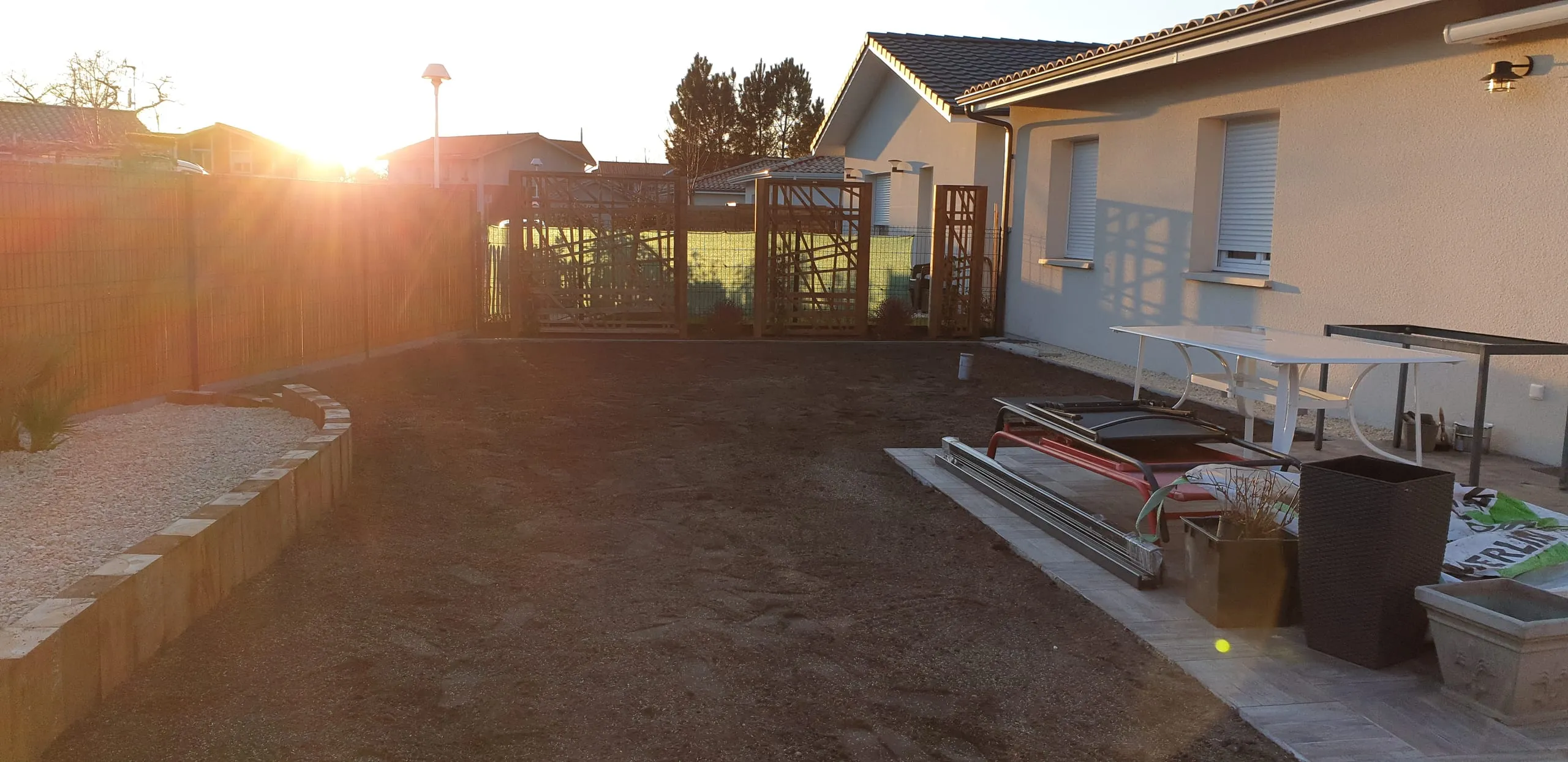 Jardin aménagé avec massif et graviers, lumière de coucher de soleil