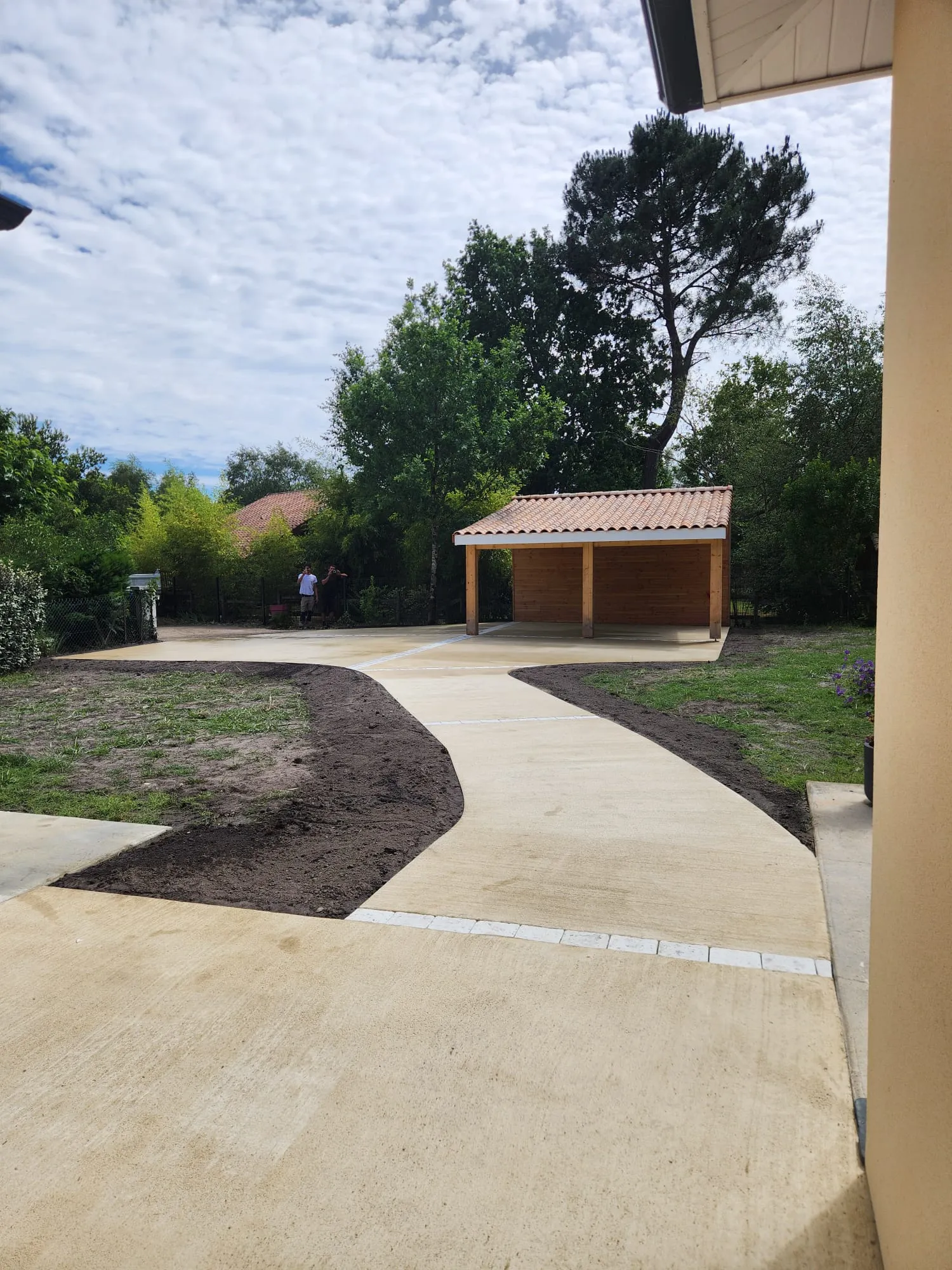 Allée en béton balayé sinueuse menant à une maison médocaine