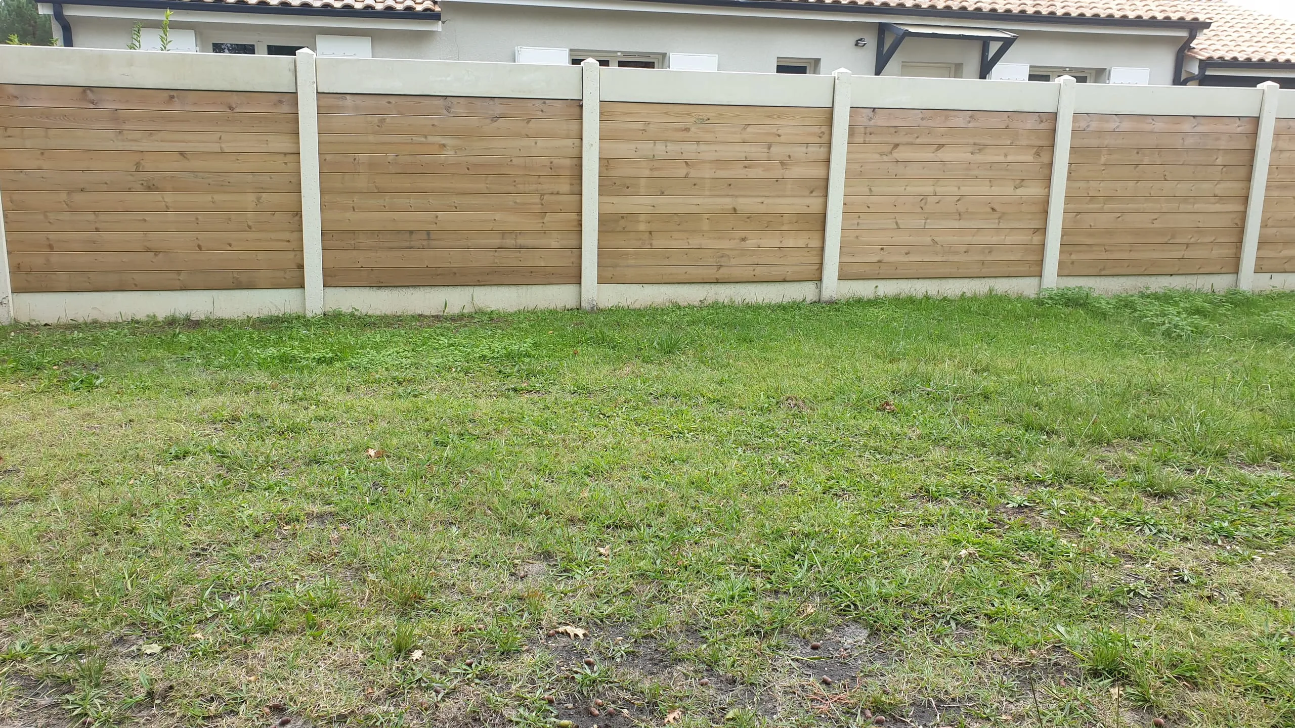 Clôture en lames de bois horizontales avec poteaux béton, propriété médocaine