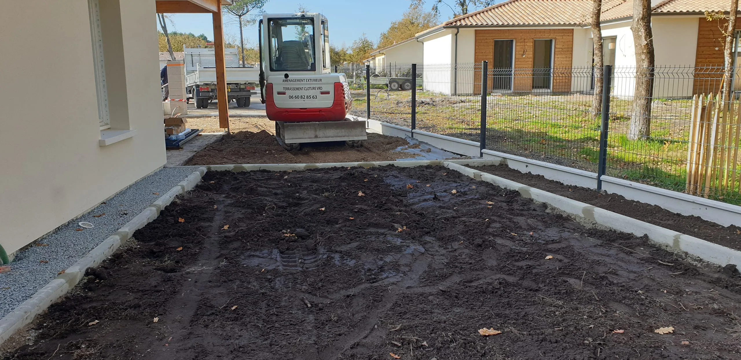 Mini-excavatrice sur chantier extérieur lors de la préparation du terrain avant enrobé