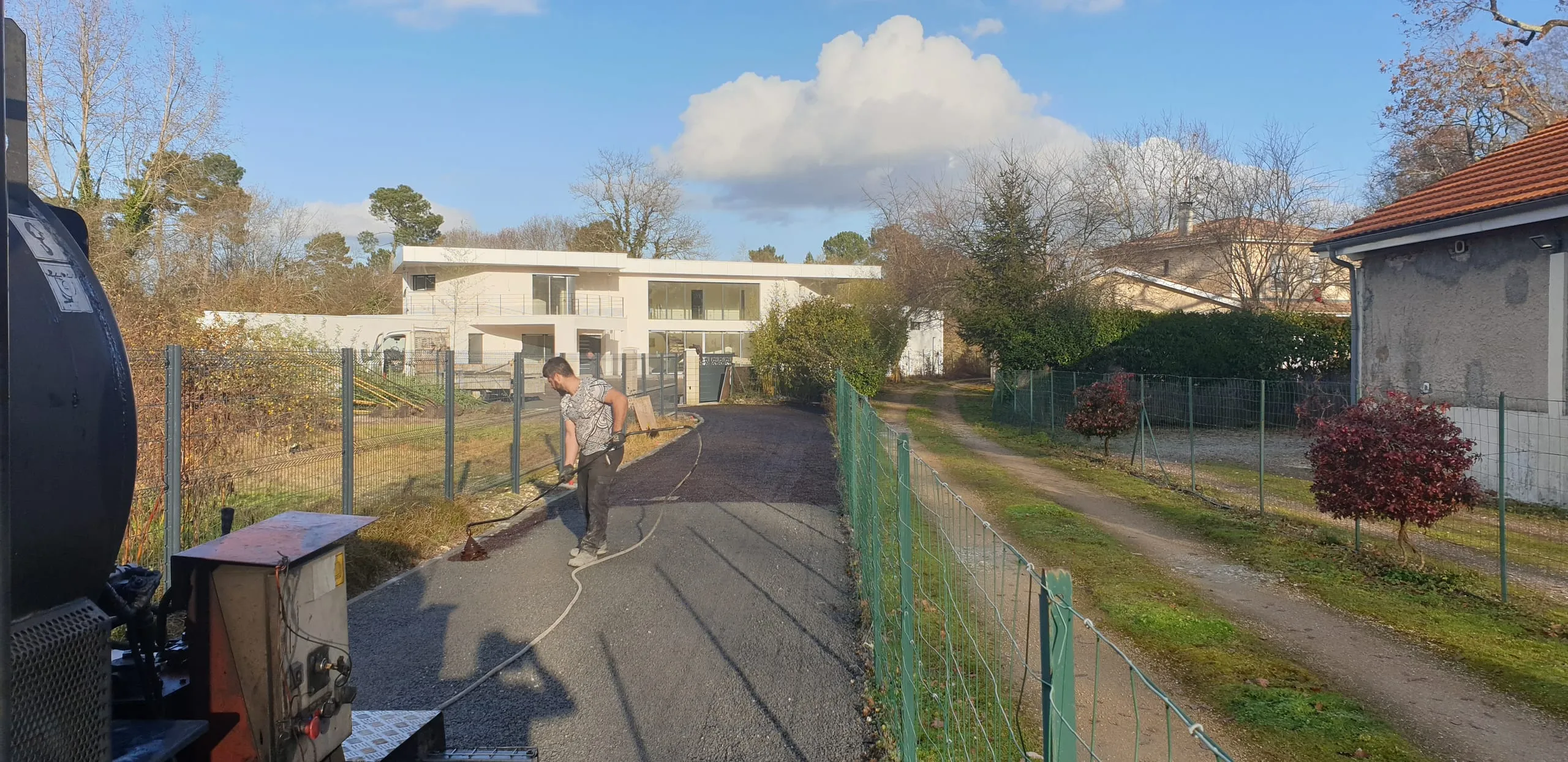 Pose d'enrobé bicouche par un ouvrier Nicolas Alves, voirie médocaine