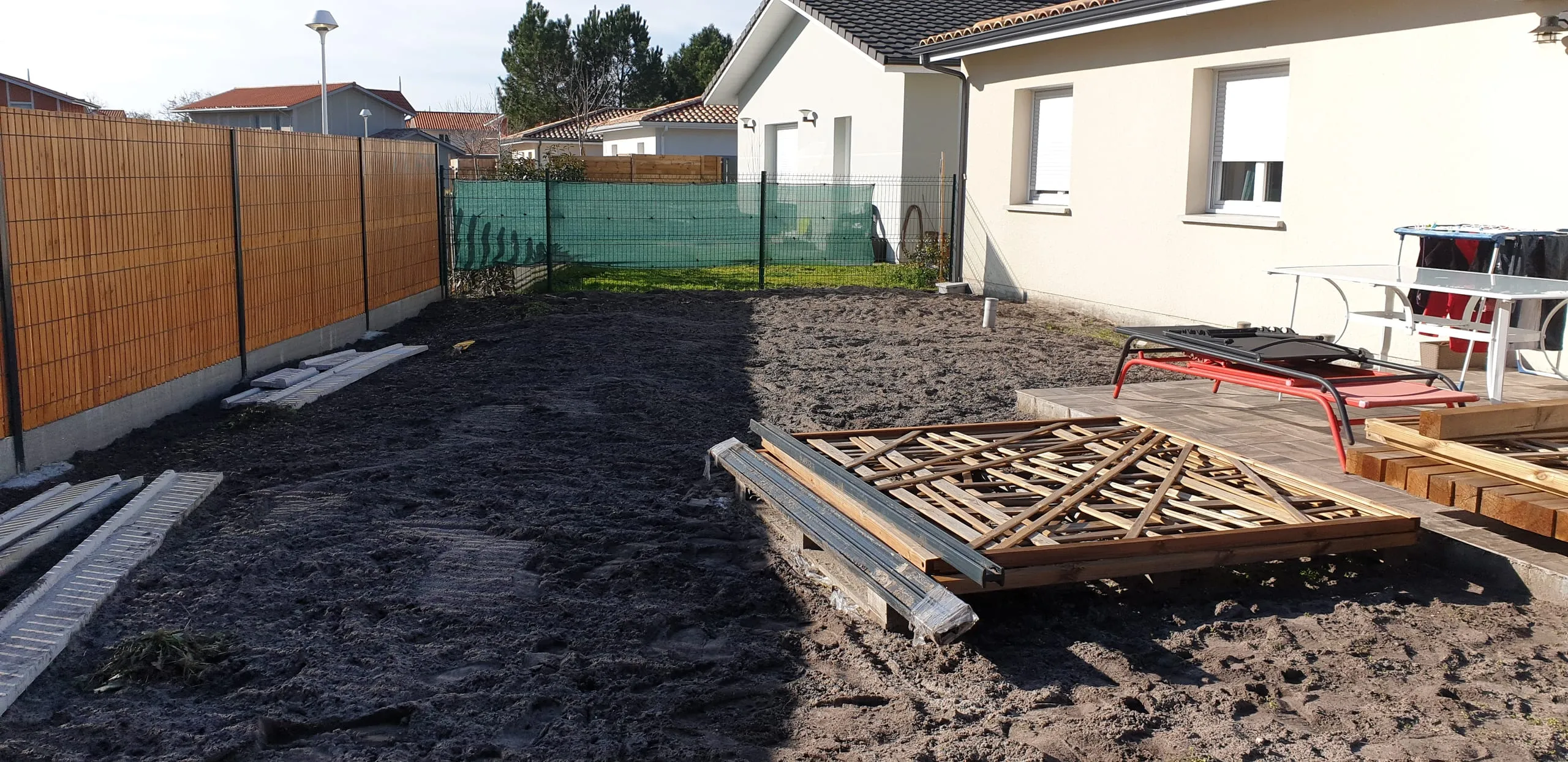 Matériaux de terrassement en attente sur chantier, délimitation par bambous