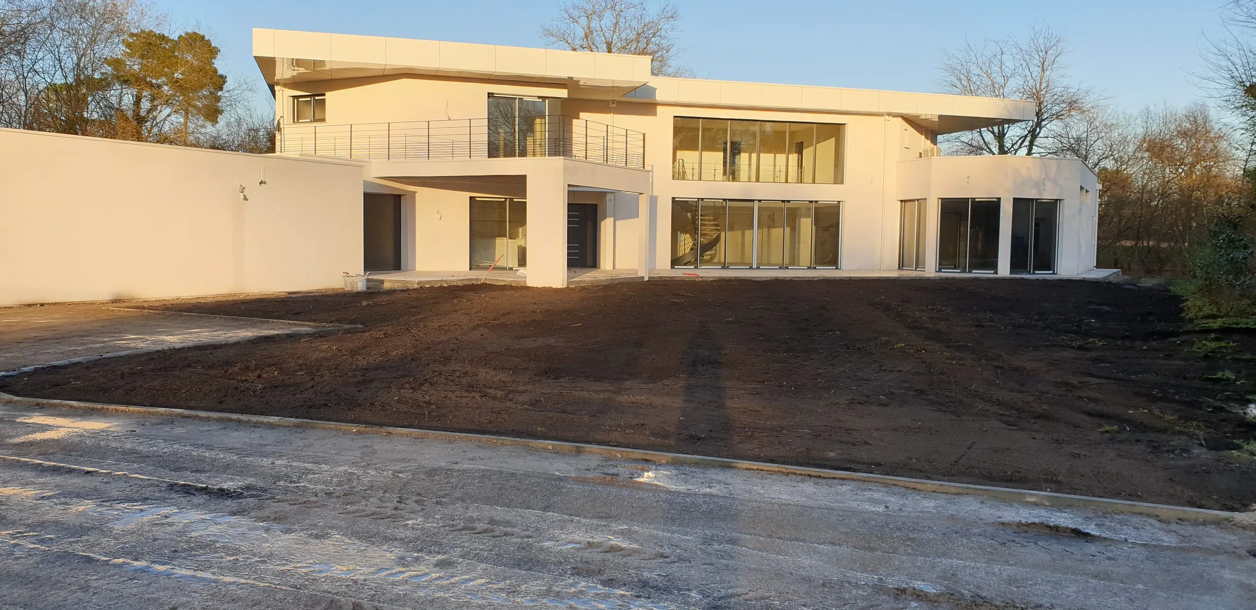 Surface bitumée et voirie autour d'une villa contemporaine dans le Médoc